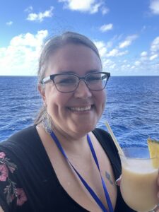 Picture of Kendie enjoying a drink by the ocean