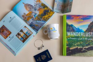 Picture of travel books, passports and a mug that says Stroede Travel.