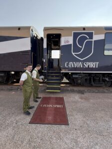 Picture of Canyon Spirit train car with open door showing carpet, staff waiting and boarding stairs.