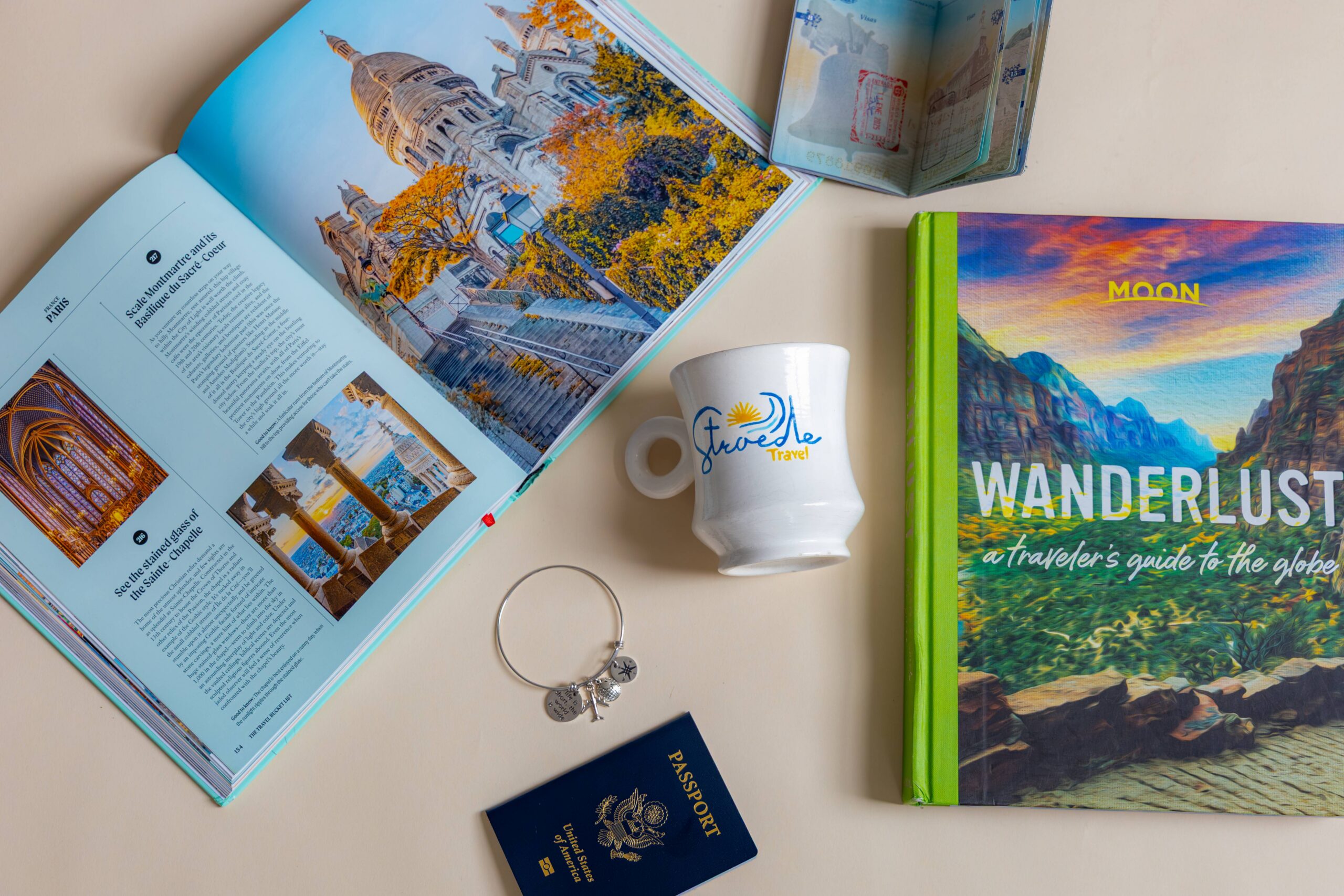 Picture of travel books, passports and a mug that says Stroede Travel.