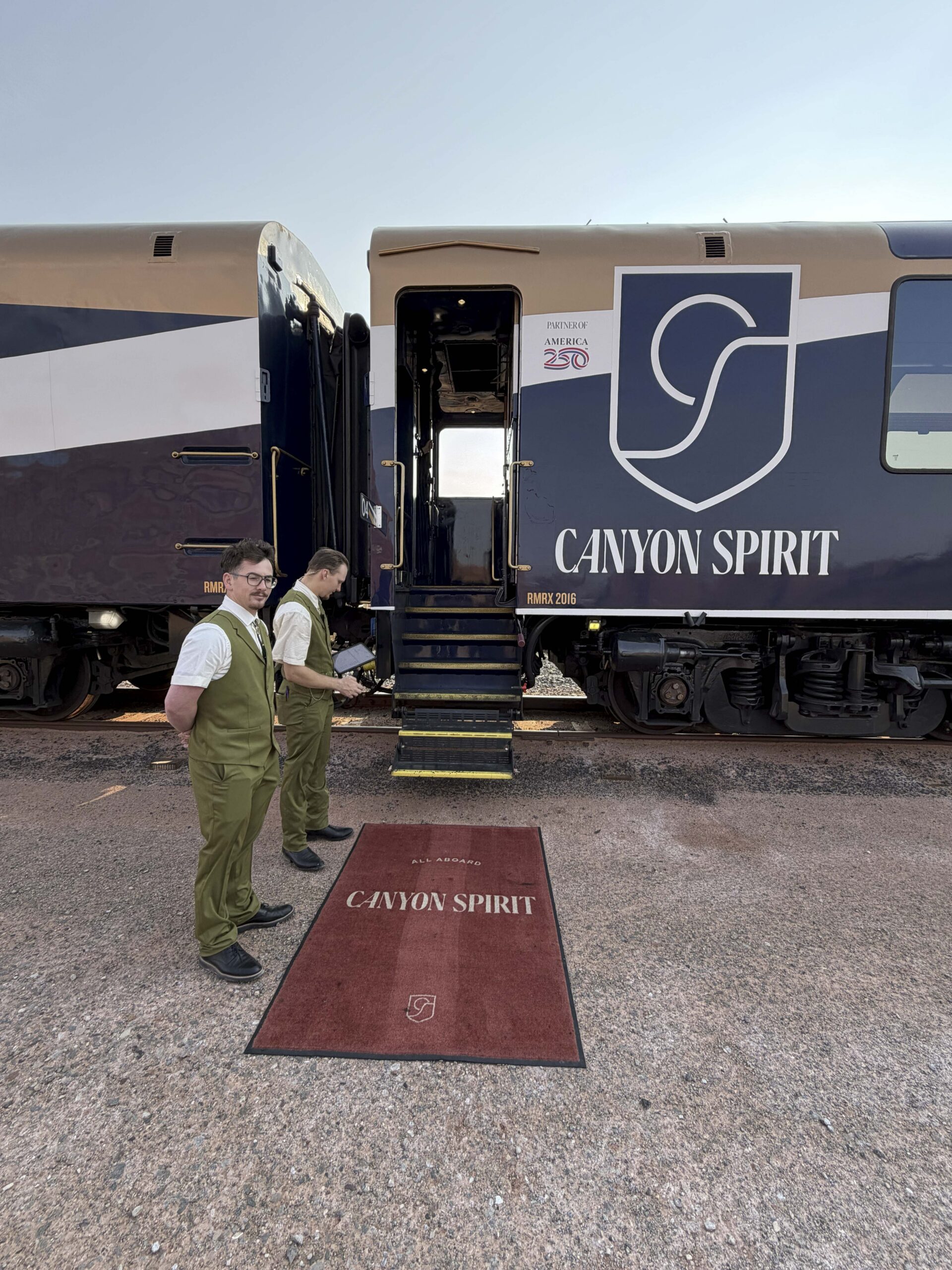 Picture of Canyon Spirit train car with open door showing carpet, staff waiting and boarding stairs.